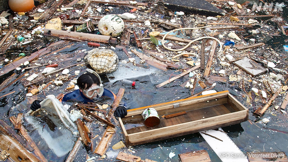 Seorang penyelam membersihkan puing-puing di Ofunato, April 2011.