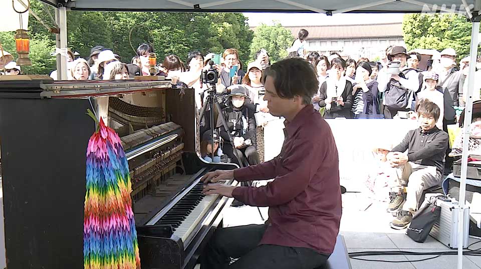 Koller memainkan piano sementara Yagawa duduk di belakangnya.
