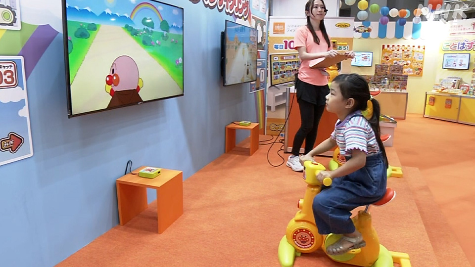 Anak-anak menaiki mainan karakter populer Anpanman dalam permainan yang dirancang agar mereka tetap aktif bergerak saat cuaca di luar terlalu panas.