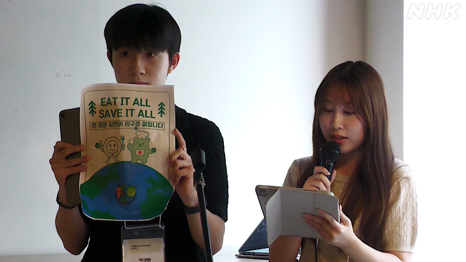 Ishii Midori dan Kwon Gyu-min mempresentasikan rencana mereka untuk menekan limbah makanan dalam forum di Sapporo.