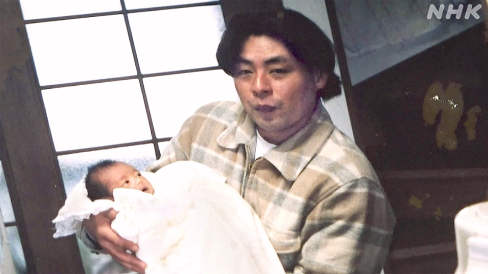 Yoshiaki mendekap putrinya, Hana, pada Maret 2000.