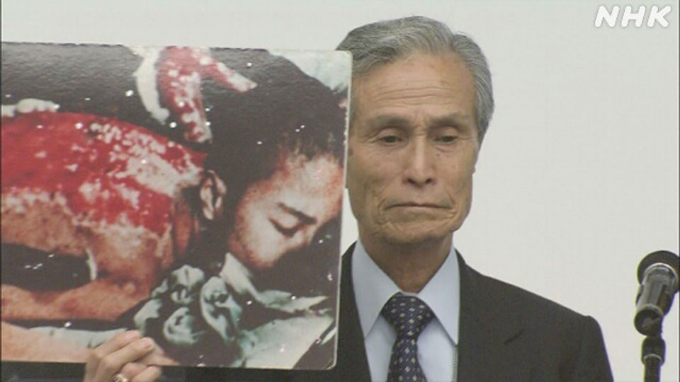 Taniguchi Sumiteru saat menyampaikan pidato pada Konferensi Peninjauan NPT 2010 sembari menunjukkan foto dirinya sendiri.
