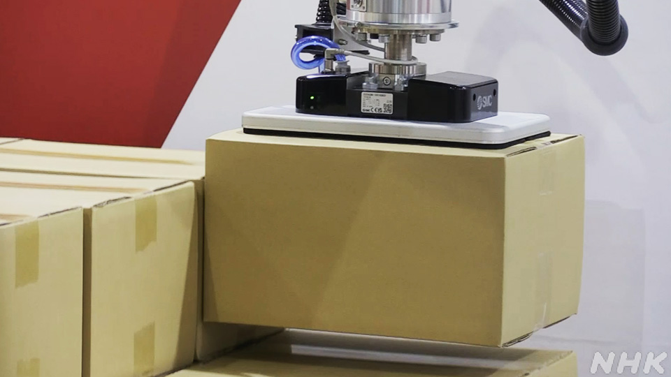 Robot industri yang dapat menggenggam paket dan menyusunnya dengan rapi dipamerkan.