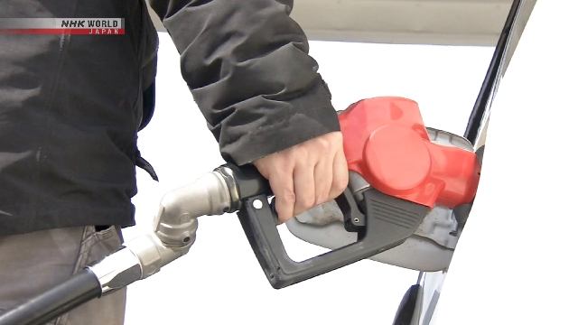 Petugas mengisi bahan bakar mobil di stasiun pengisian bahan bakar di Jepang