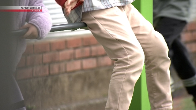 Anak-anak dan keluarga berjalan di kawasan permukiman di Jepang.