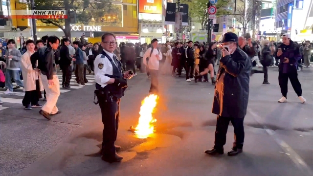 Petugas menangani lokasi insiden kebakaran di persimpangan scramble Shibuya di Tokyo pada malam hari.