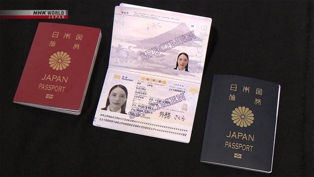Tumpukan paspor Jepang dengan latar belakang peta dunia.