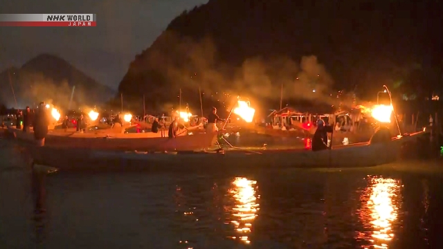 Pawang kormoran dengan kostum tradisional mengendalikan burung kormoran untuk menangkap ikan di Sungai Nagara yang diterangi perapian gantung.