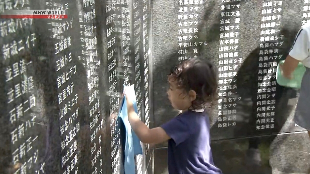 Warga membersihkan lempengan batu di Cornerstone of Peace, Taman Peringatan Perdamaian Itoman, Okinawa, menjelang Hari Peringatan Okinawa.