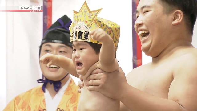 Bayi digendong orang dewasa di ring sumo saat kontes sumo menangis di Kota Date, Fukushima