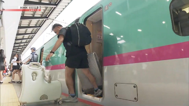 Suasana keramaian penumpang membawa koper di stasiun kereta Jepang saat arus balik libur Bon
