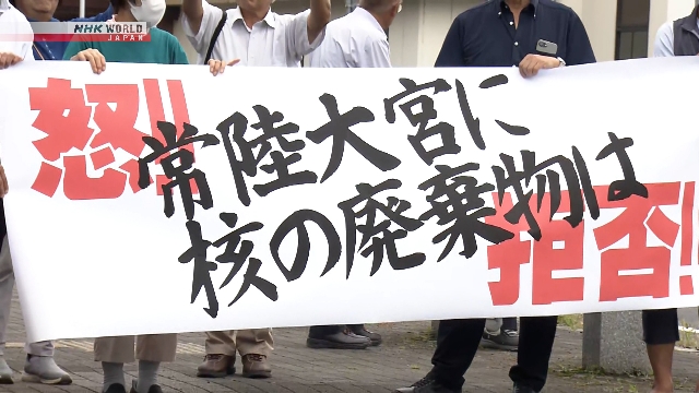 Warga berdemonstrasi membawa poster penolakan survei pembuangan limbah nuklir di depan Balai Kota Hitachiomiya, Prefektur Ibaraki